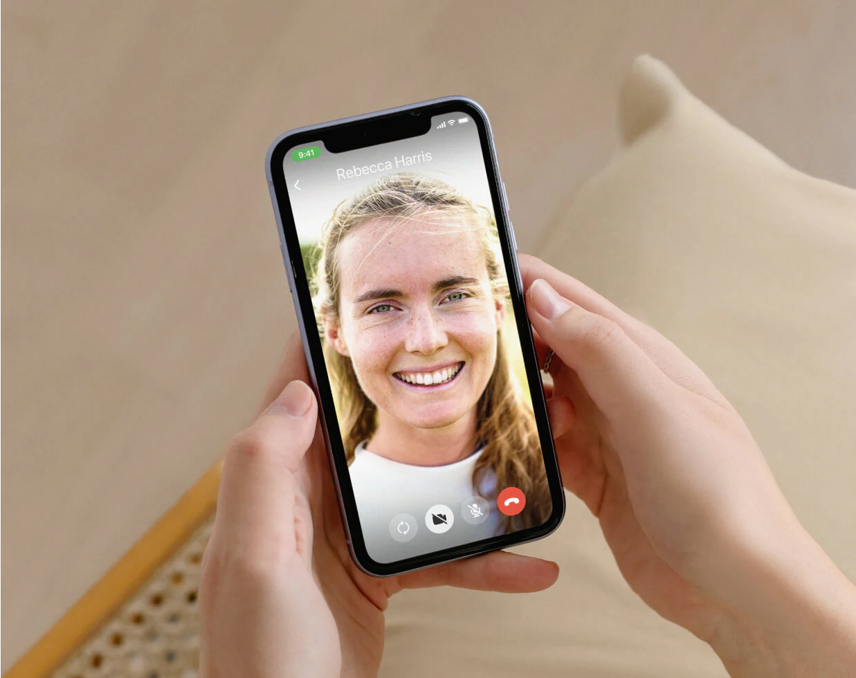 Woman holding a phone displaying the Liva app, receiving health coaching through a live video call