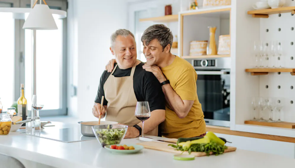 Couple smiling as they cook healthy food together
